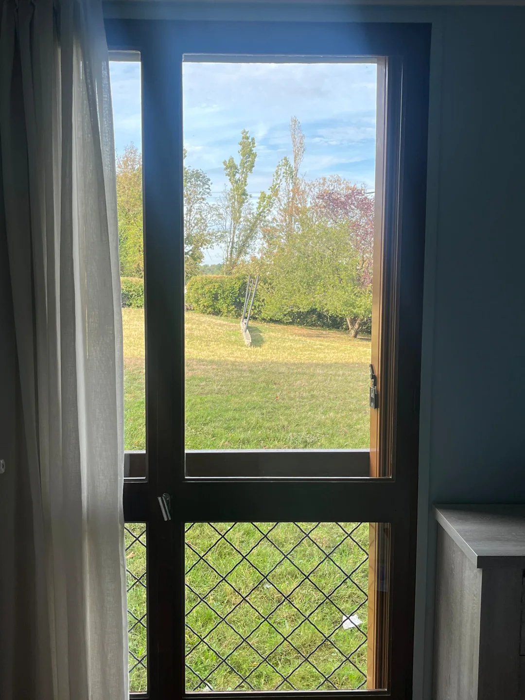 Porte-fenêtre vitrée nettoyée par CIGINET avec vue sur un jardin