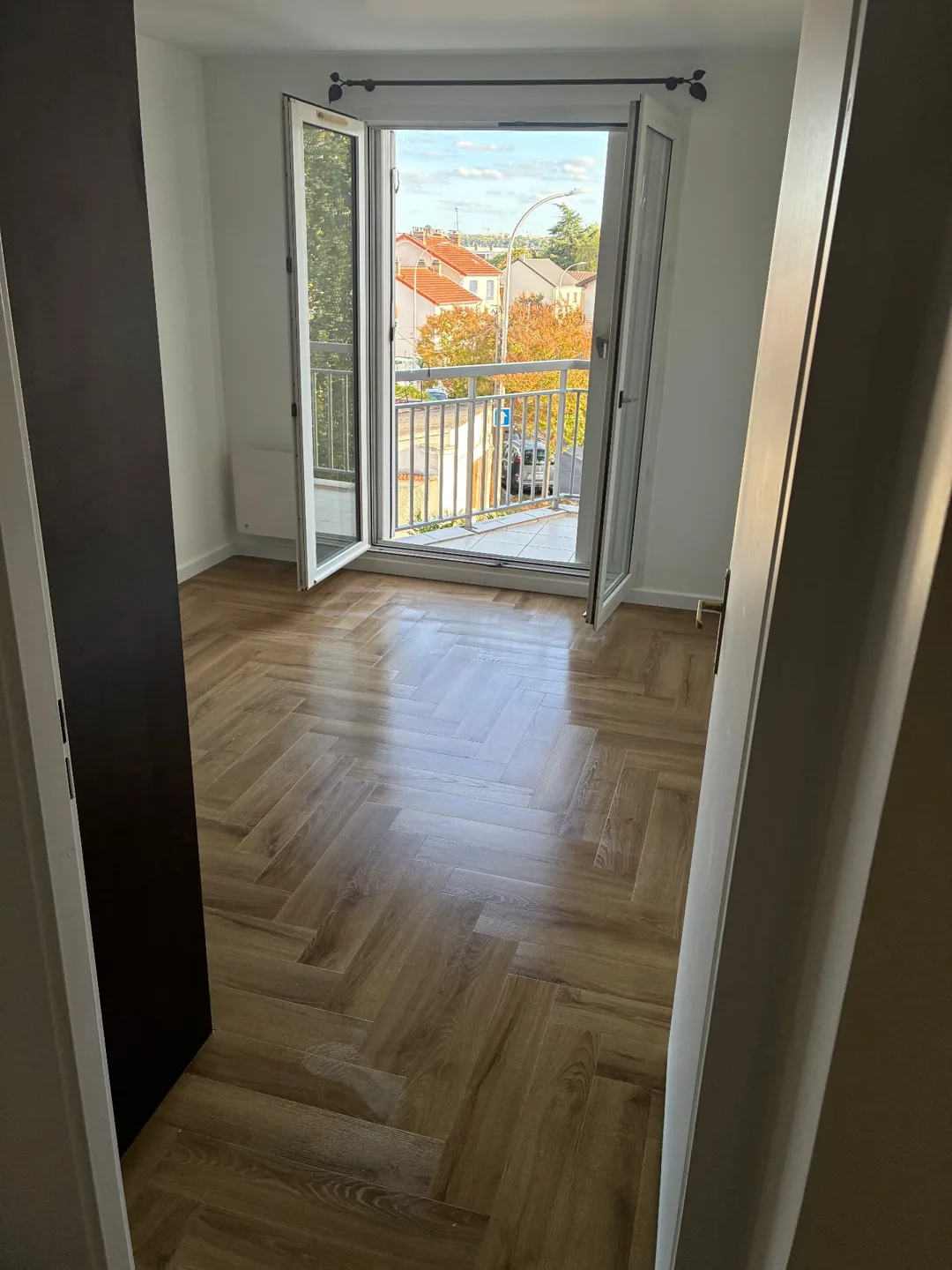 Chambre avec parquet nettoyé et porte-fenêtre ouverte après un nettoyage de fin de bail – CIGINET